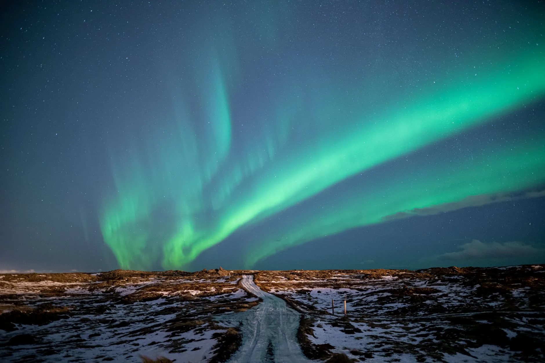 Aurores boréales vertes dansant au-dessus d'un paysage islandais enneigé