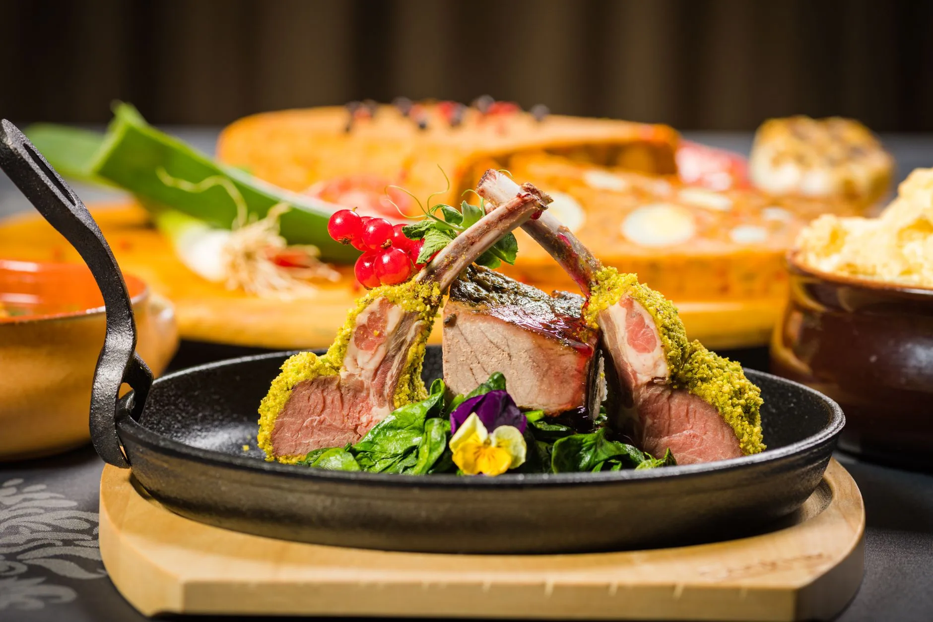 Carré d'agneau en croûte d'herbes servi avec ses accompagnements